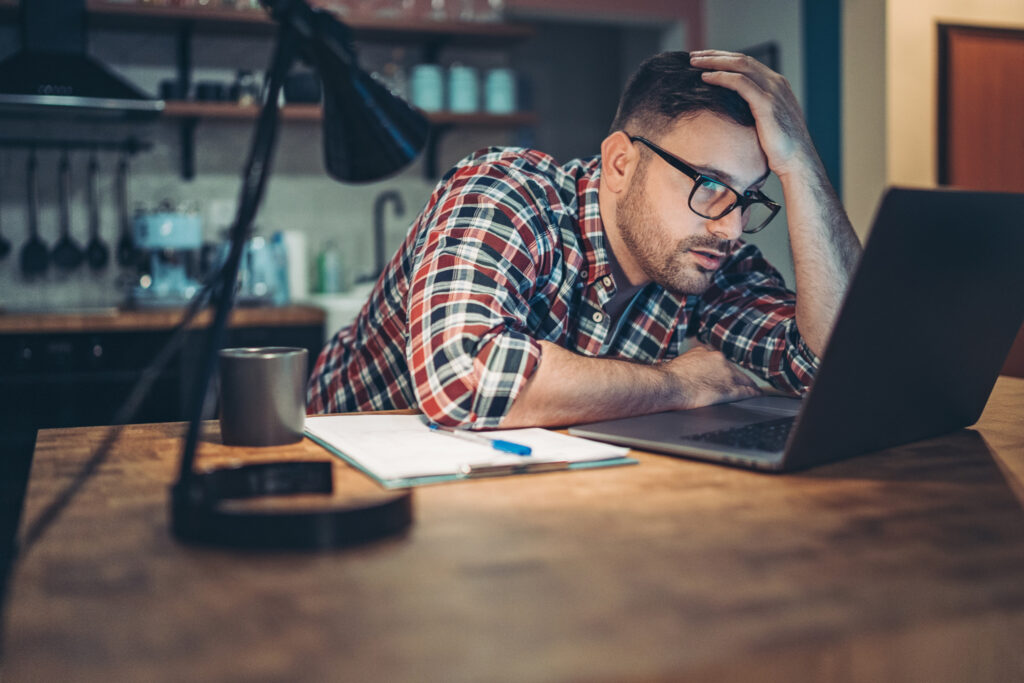 Stressed man on computer at home