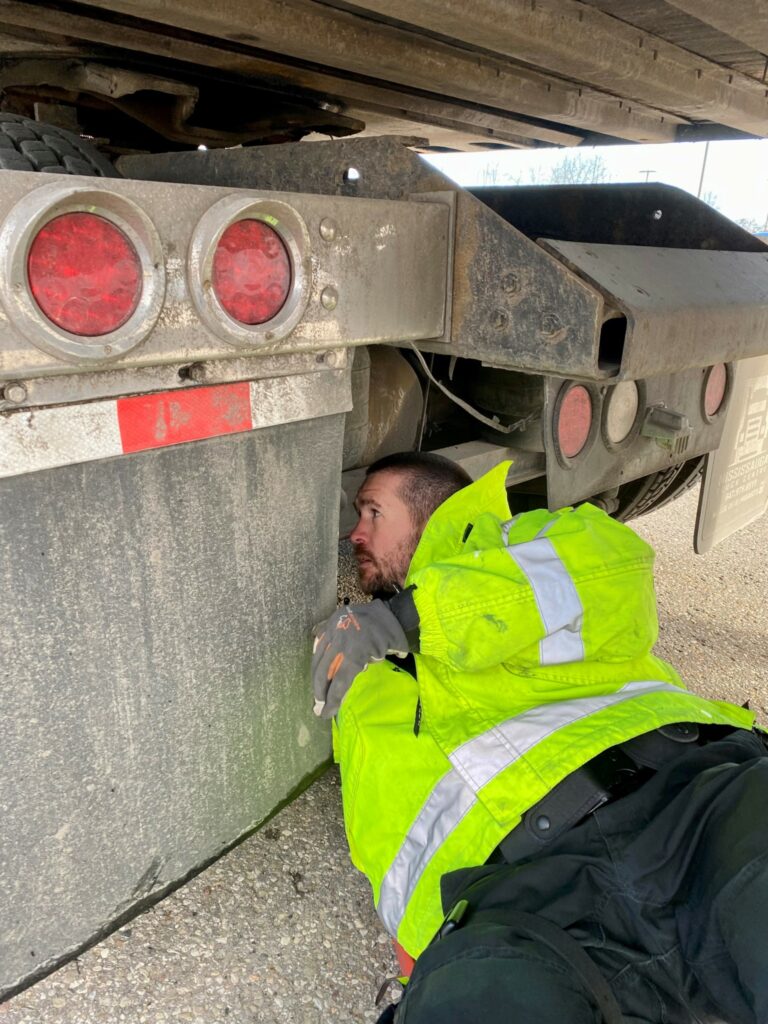 Police officer inspecting a truck